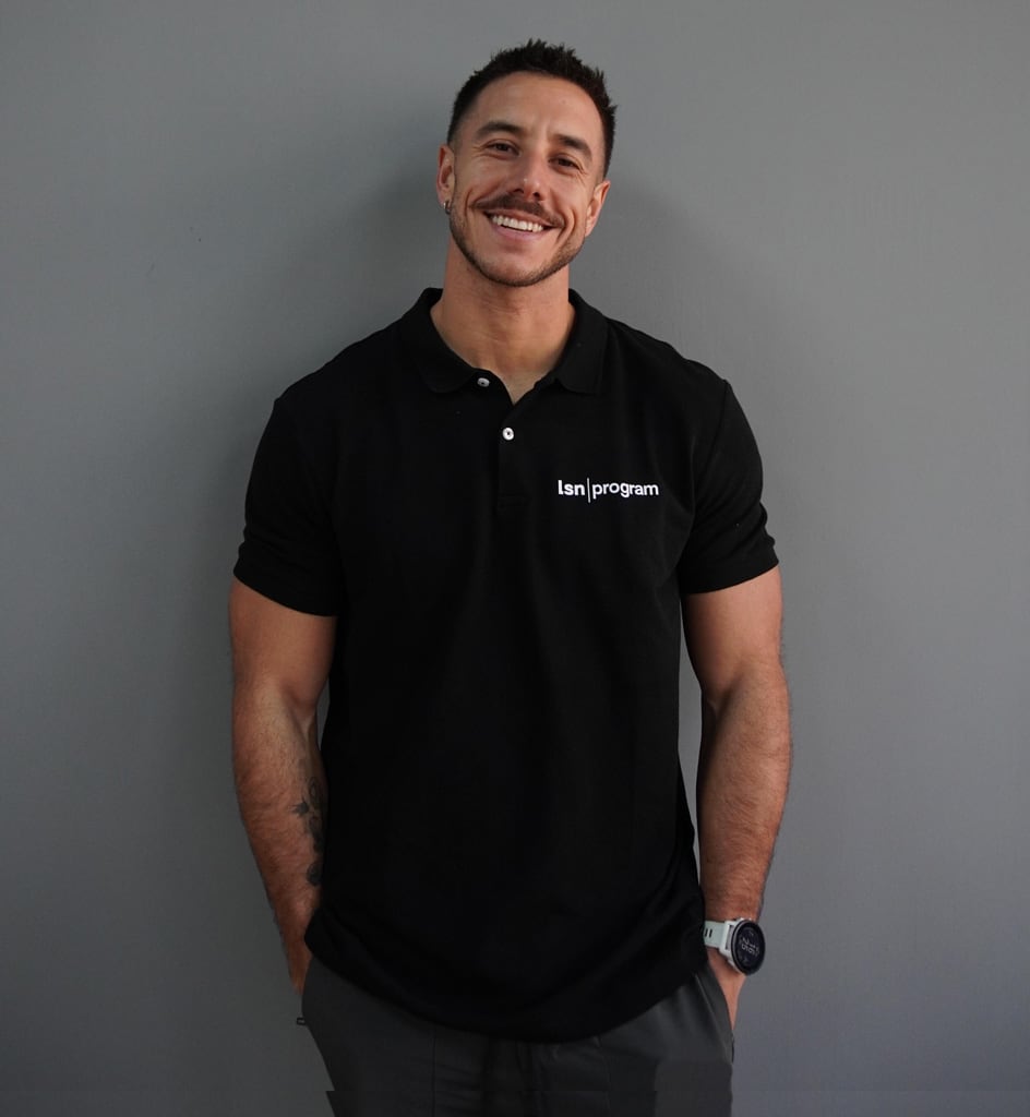 Entrenador posando con una camiseta negra.